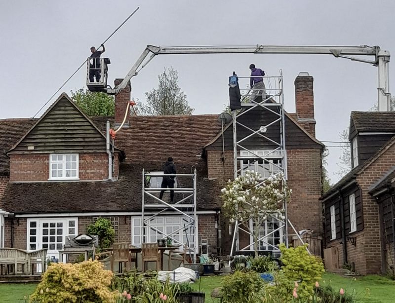 The Roof Moss Cleaners using cherry picker and scaffolding to clean roof safely and professionally in Burgess Hill, West Sussex